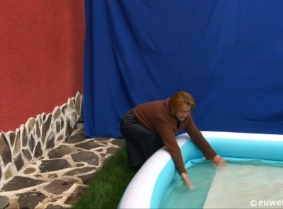 Lili is playing on the kiddy pool wearing a denim skirt, low heeled, cowboy boots and a brown cardigan over a black thin blouse.
The boots will come off for a while during the clip and the cardigan is also removed at some point.

And Liliane had a wond